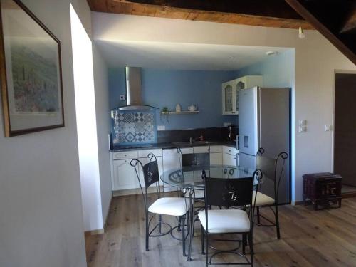a kitchen with a table and chairs in a room at Gîte de Ségonzac in Villecomtal