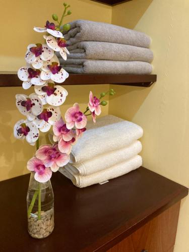 a vase of flowers on a table with towels at Casa Mono del Río in Matapalo