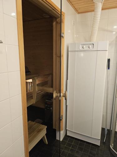 a kitchen with a white refrigerator in a room at Ruka Chalets Ski-In 1313 in Ruka