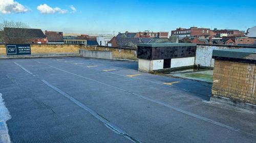 an empty parking lot with buildings in the background at The George Wright Boutique Hotel, Bar & Restaurant in Rotherham