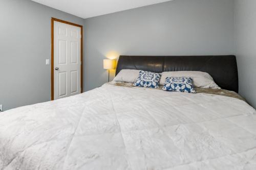 a bedroom with a large white bed with blue pillows at Cozy 2-Bedroom Basement Suite Retreat Calgary in Calgary