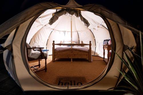 The Getaway - Seascape Belle Tent - Couples Luxury Glamping Belle Tent في دونغارفان: غرفة بسرير في خيمة