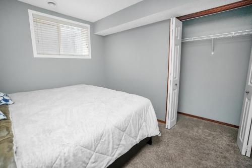 a bedroom with a bed and a window at Cozy 2-Bedroom Basement Suite Retreat Calgary in Calgary