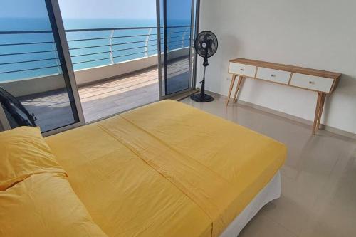 a bedroom with a yellow bed and a balcony at frente al mar 21d in Tonsupa