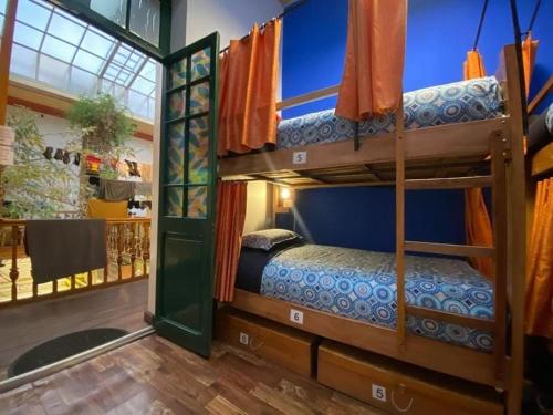 a bedroom with two bunk beds in a house at SAINT PETER'S LLAMA HOSTAL in La Paz