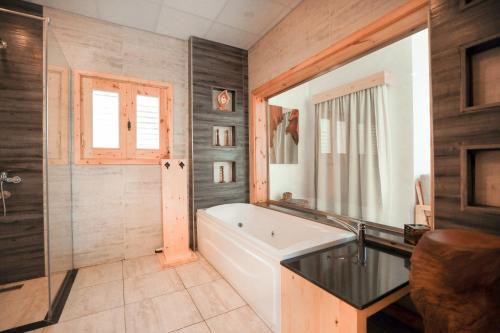 達哈布的住宿－NEOM DAHAB - - - - - - - - - - - Your new hotel in Dahab with private beach，一间带浴缸和大镜子的浴室