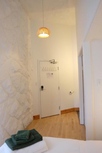 Habitación con pared de piedra y puerta blanca. en Auberge Mélilot, en Dolbeau