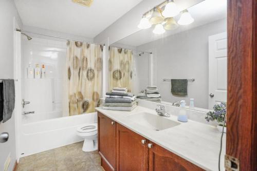 uma casa de banho com um lavatório, um WC e um chuveiro em Cozy 2-Bedroom Basement Suite Retreat Calgary em Calgary