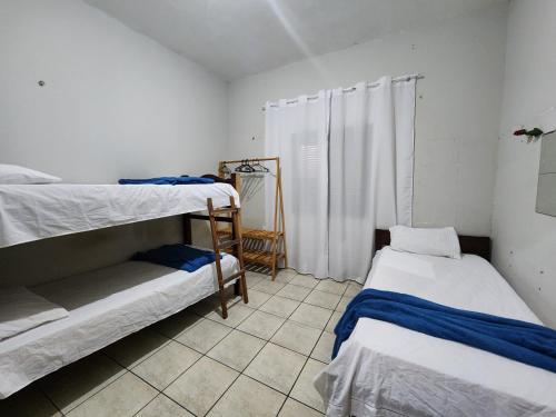 a room with two bunk beds and a tiled floor at Mini Hostel in Tutóia