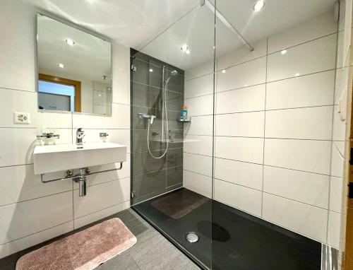 a bathroom with a shower and a sink at Haus Chalet Arnika in Saas-Grund