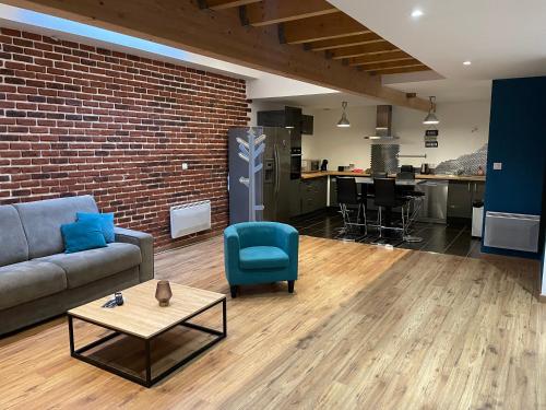 a living room with a couch and a table and a kitchen at Loft Angouleme Gare in Angoulême