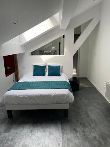 um quarto com uma cama grande e almofadas azuis em Loft Angouleme Gare em Angoulême