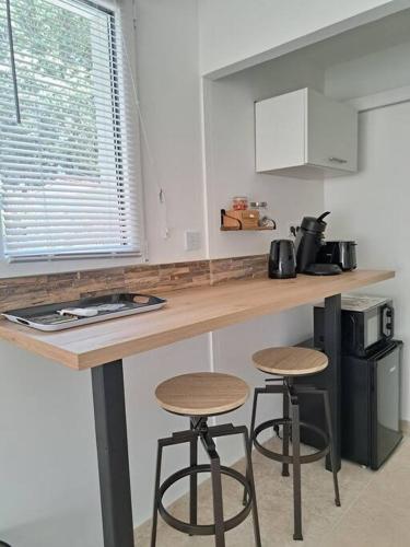 une cuisine avec deux tabourets de bar à un comptoir dans l'établissement La Madoca, à Flayosc