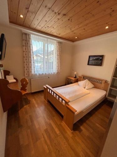 a bedroom with a large bed and a window at Alpenhostel "Das Besenhaus" in Altenmarkt im Pongau