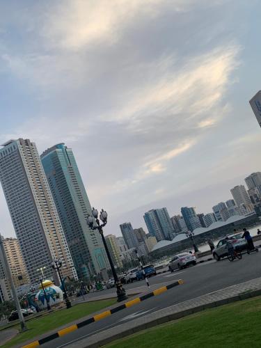 a city with tall buildings and a street with cars at Studio Apartment in Sharjah