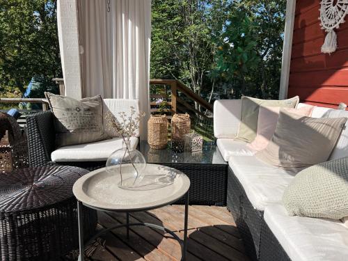 a patio with two couches and a table at Charmigt hus på Vindö in Stockholm