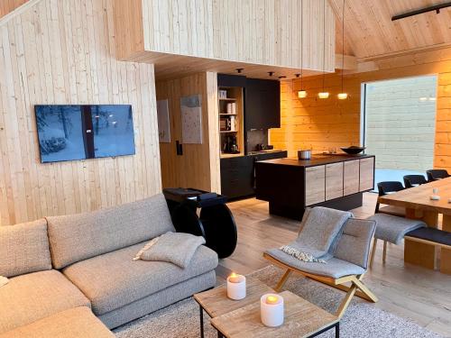 a living room with a couch and a kitchen at Kimmelvilla - Wilderness in your living room in Pyhätunturi