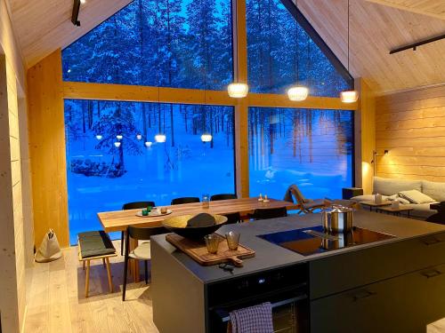a kitchen and living room with a large window at Kimmelvilla - Wilderness in your living room in Pyhätunturi