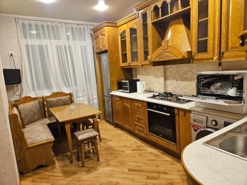 a kitchen with wooden cabinets and a table and a dining room at Parkview Family Apart in Baku
