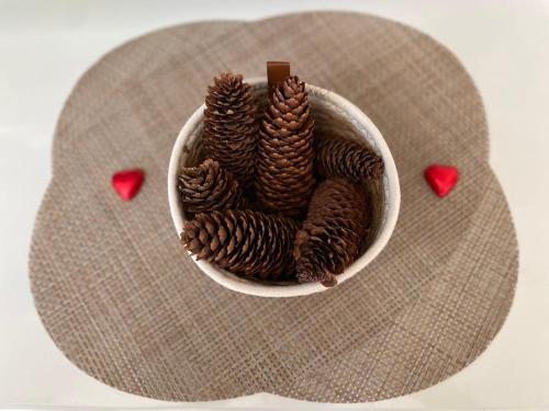 un bol blanc rempli de cônes de pin et de coeurs rouges dans l'établissement Les yeux du lac, à Gérardmer