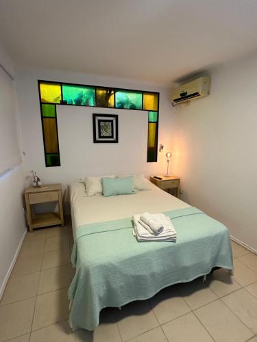 a bedroom with a bed with stained glass windows at Tiny Room Ingá in Colón
