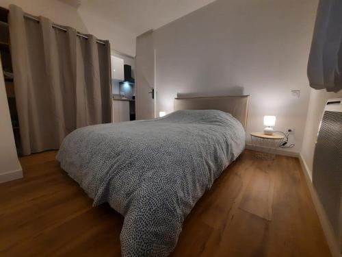 um quarto com uma cama grande e piso em madeira em T2 Chic Green & Yellow em Mazamet