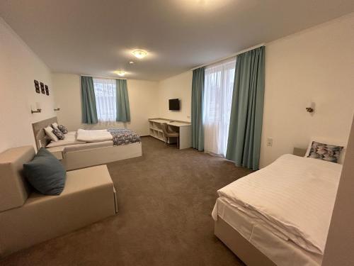 Pokój hotelowy z 2 łóżkami i biurkiem w obiekcie Danelis Hotel w mieście Edelény