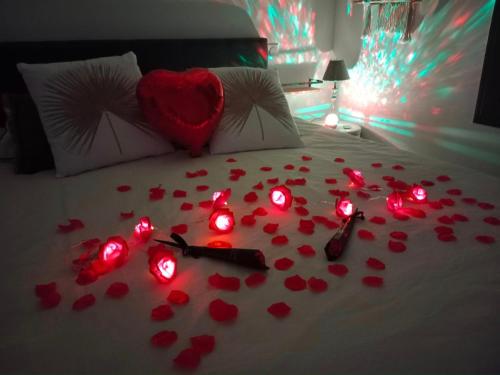 una cama con corazones rojos y luces en ella en Ô'BEL AIR, en Azur
