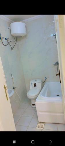 biała łazienka z toaletą i wanną w obiekcie شالية مون لايت w mieście Umm Lajj