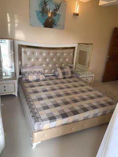 a bedroom with a large bed with a checkered mattress at Good Time Guaranteed •7 in Dakar