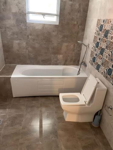 a bathroom with a toilet and a bath tub at Good Time Guaranteed •7 in Dakar