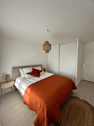 sypialnia z dużym łóżkiem i pomarańczowym kocem w obiekcie Annecy gare w Annecy