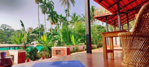 a room with a chair and a view of a resort at The Ixora - A Boutique Homestay in Varkala