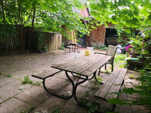 a wooden picnic table and chairs in a yard at Midtown Toronto Next to Subway Line 1 in Toronto