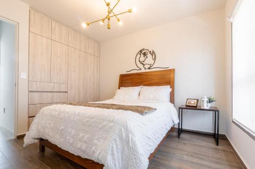 een slaapkamer met een groot bed met een houten hoofdeinde bij Encantadora propiedad Equipado en la Ciudad in La Cañada
