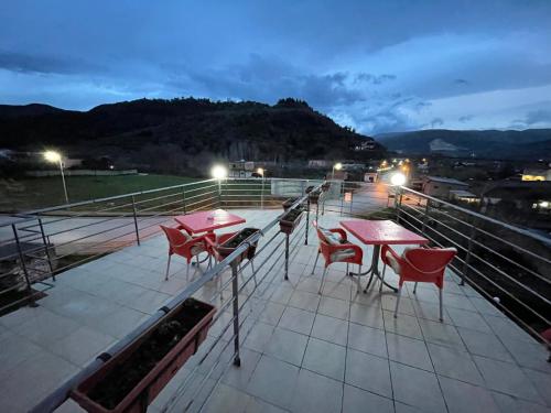 a couple of tables and chairs on a deck at night at Hotel Bar Restaurant Mete in Peshkëpi