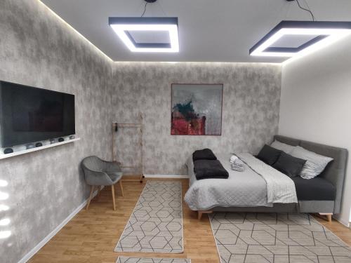 een slaapkamer met een bed en een flatscreen-tv bij Apartmani Park in Novi Pazar