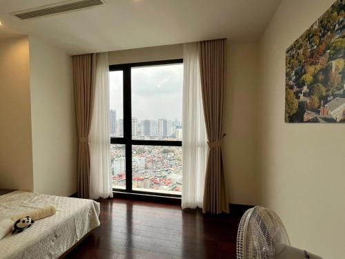 een slaapkamer met een groot raam met uitzicht bij Vinhomes Royal City#3BR Serviced Apartment in Hanoi
