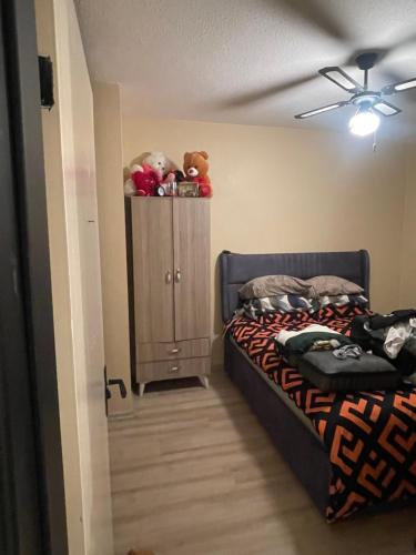 1 dormitorio con 1 cama y armario con animales de peluche en 1+1 lüx daire en Estambul