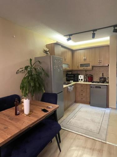 伊斯坦堡的住宿－1+1 lüx daire，厨房配有木桌和不锈钢冰箱。
