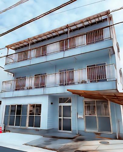 a white building with balconies on top of it at VacationStay Oita Saiki UND 貸別荘 in Saiki