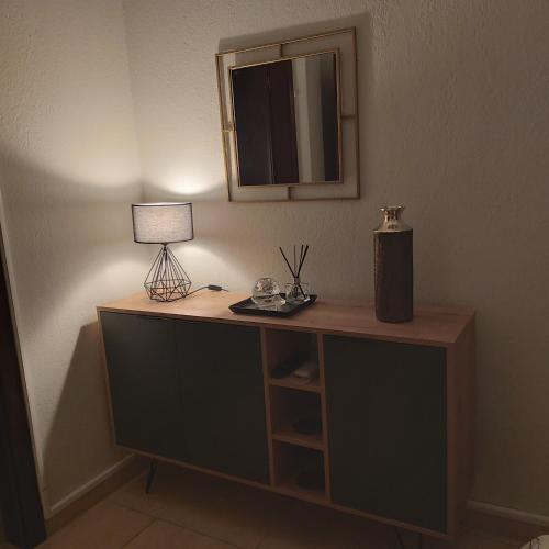 Cette chambre comprend un bureau avec une lampe et un miroir. dans l'établissement Vaggoula's Luxury Apartment 1, à Serres