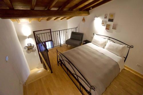 una camera con un grande letto e una sedia di Casetta Ines, your stay in the city center a Viterbo