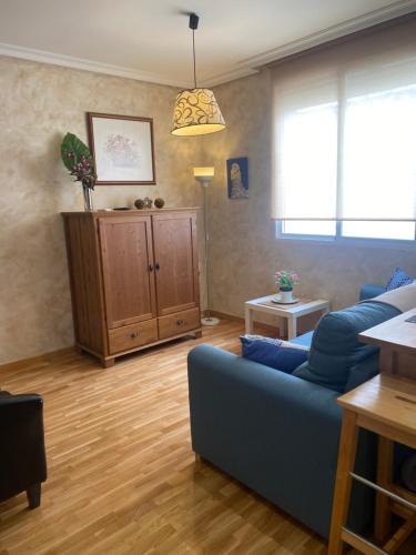 a living room with a blue couch and a table at Apartamento La Plazuela in Almagro