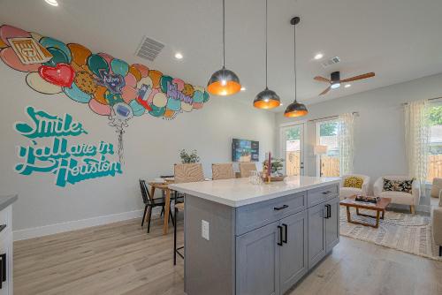 a kitchen with an island in a room with a balloon wall at Boho Chic Retreat with Unique Photo Op, King Bed, Private Backyard & Free Parking - 8 Mins from Downtown! in Houston