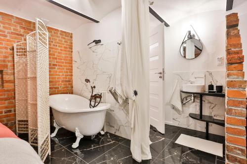 a bathroom with a white tub and a sink at Apartament Zielona Willa in Skomielna Biała