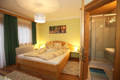 a bedroom with a bed and a bathroom with a shower at Bauernhof Haufhof Pension, Haus im Ennstal bei Schladming in Haus im Ennstal