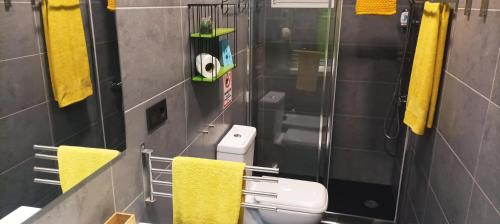 La salle de bains est pourvue de toilettes et de serviettes jaunes. dans l'établissement LA BOHEME, à Telde
