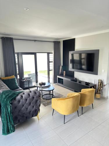 a living room with a couch and a tv at Cosy & Comfy Paradiso in Nelspruit