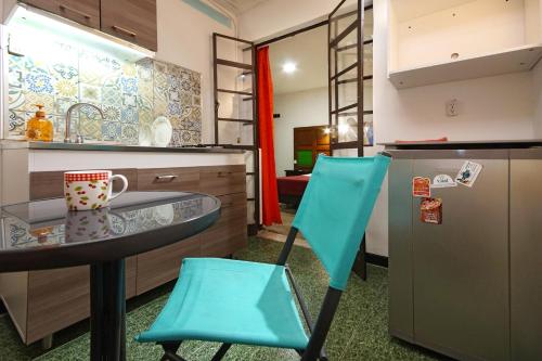 a kitchen with a table and two blue chairs at Ding-Dong Hostel in Cali